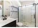 Bathroom featuring a vanity, sliding glass shower door, updated lighting, and decorative shelving at 217 Hydrangea Dr, Clover, SC 29710