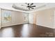 Spacious main bedroom featuring tray ceilings, hardwood floors, and multiple windows at 217 Hydrangea Dr, Clover, SC 29710