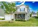 Charming two-story home with a covered front porch and well-maintained landscaping, complemented by lush green lawns at 217 Hydrangea Dr, Clover, SC 29710