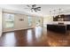 Open-concept living room with hardwood floors, ceiling fan, and lots of natural light from large windows at 217 Hydrangea Dr, Clover, SC 29710