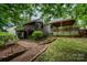 Spacious backyard featuring a deck, covered patio, lush greenery, and a well-manicured lawn at 2342 Castlecomer Dr, Charlotte, NC 28262