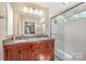 Modern bathroom featuring a double vanity with granite countertops and a glass-enclosed shower at 2342 Castlecomer Dr, Charlotte, NC 28262