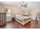 Cozy bedroom featuring a tray ceiling, dark wood floors, and plush, neutral-toned furniture at 2342 Castlecomer Dr, Charlotte, NC 28262