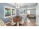 Inviting dining area with hardwood floors, a rustic table, and a view of the cozy living room at 2342 Castlecomer Dr, Charlotte, NC 28262