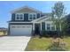 Two-story home featuring a two-car garage, manicured lawn, and pleasant landscaping at 2635 Tillman St, Monroe, NC 28112