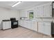 Functional kitchen featuring white cabinets, essential appliances, and laminate flooring for easy maintenance at 2729 S Ridge Ave, Concord, NC 28025