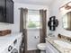 Laundry area with a washing machine, granite sink, and a modern vanity at 2816 Eastport Rd, Charlotte, NC 28205