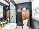 Modern bathroom with black walls, white sink, glass shower, and updated vanity at 2816 Eastport Rd, Charlotte, NC 28205
