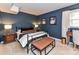 Comfortable bedroom featuring neutral carpet, a metal bed frame, and dark blue accent walls at 2816 Eastport Rd, Charlotte, NC 28205