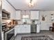 Kitchen with white cabinets, tile backsplash, stainless steel appliances, granite countertops and an area rug at 2816 Eastport Rd, Charlotte, NC 28205