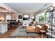 Open living space with hardwood floors, featuring a leather sofa and adjacent dining area at 2816 Eastport Rd, Charlotte, NC 28205