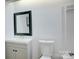Bright bathroom with a modern vanity, black framed mirror, and sleek fixtures at 2916 Iron Gate Ln, Charlotte, NC 28212