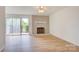 Bright living room featuring hardwood floors, brick fireplace, and sliding glass doors to the outside at 2916 Iron Gate Ln, Charlotte, NC 28212