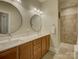 Bathroom showcasing double sinks, a large mirror, and a walk-in shower with tiled walls and a bench at 3002 Portico Pl, Tega Cay, SC 29708