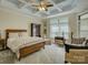 Bedroom featuring a tray ceiling, large window, and comfortable seating area with stylish decor at 3002 Portico Pl, Tega Cay, SC 29708