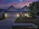 Inviting home exterior at dusk, featuring manicured landscaping and warm lighting at 3002 Portico Pl, Tega Cay, SC 29708