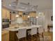 Bright kitchen featuring a large marble island with seating, stainless steel appliances, and custom cabinetry at 3002 Portico Pl, Tega Cay, SC 29708