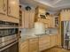 Kitchen with light wood cabinetry, stainless steel appliances, and a gas stovetop with white tile backsplash at 3002 Portico Pl, Tega Cay, SC 29708
