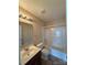 Bathroom with wood vanity, single sink, and shower-tub combo with white tiling at 3527 Creeping Flora Ln, Charlotte, NC 28216