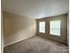 Large bedroom with carpet, neutral paint, two windows, and a closet, offering comfort and natural light at 3527 Creeping Flora Ln, Charlotte, NC 28216