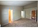 Large carpeted bedroom with neutral paint and multiple doorways, including access to a closet and the hallway at 3527 Creeping Flora Ln, Charlotte, NC 28216