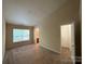 Bedroom featuring neutral walls and carpet, a large window, and an ensuite bathroom at 3527 Creeping Flora Ln, Charlotte, NC 28216