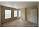 Bedroom with neutral carpet, two windows offering natural light, and doorways leading to other rooms at 3527 Creeping Flora Ln, Charlotte, NC 28216