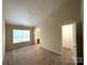 Spacious carpeted bedroom with a large window, neutral paint, and access to an en-suite bathroom and closet at 3527 Creeping Flora Ln, Charlotte, NC 28216