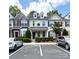 A view of the townhome exterior with red shutters, a green door and parking at 3527 Creeping Flora Ln, Charlotte, NC 28216