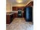 Efficient kitchen featuring dark wood cabinets, a full appliance package, and tiled flooring for easy maintenance at 3527 Creeping Flora Ln, Charlotte, NC 28216