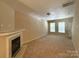 Spacious living room featuring a cozy fireplace and neutral carpeting at 3527 Creeping Flora Ln, Charlotte, NC 28216