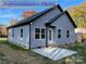 Home featuring gray siding, black trim, and a concrete patio, perfect for outdoor entertaining at 404 N Peterson St, Stanley, NC 28164