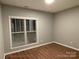 Neutral bedroom with a large window, wood-look floors, and a minimal, clean design at 404 N Peterson St, Stanley, NC 28164