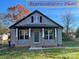 Attractive home with a cozy front porch, gray siding, and well-maintained landscaping at 404 N Peterson St, Stanley, NC 28164