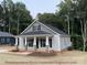 Stylish home with a covered front porch, gray siding, and well-manicured lawn at 404 N Peterson St, Stanley, NC 28164