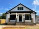 Elegant home featuring white siding, black accents, and a welcoming front porch at 404 N Peterson St, Stanley, NC 28164