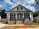 Charming home with a covered front porch, light blue siding, and decorative railings at 404 N Peterson St, Stanley, NC 28164
