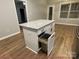 Kitchen island featuring granite countertops, white cabinets, and a pull-out trash compartment at 404 N Peterson St, Stanley, NC 28164