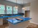 Bright kitchen features white cabinets, blue tile backsplash, and a large island with blue countertop at 408 Nathaniel Way # Brx0053, Charlotte, NC 28213