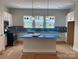 Bright kitchen features white cabinets, blue tile backsplash, and a large island with blue countertop at 408 Nathaniel Way # Brx0053, Charlotte, NC 28213