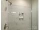 Close up of shower fixtures and marble style tile with a built in niche at 408 Nathaniel Way # Brx0053, Charlotte, NC 28213