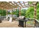 Back deck with wood pergola features a barbecue grill, white railing, and rocking chairs at 430 Edgegreen Dr, Charlotte, NC 28217