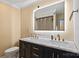 Bathroom with double sink vanity with a large illuminated mirror and gold hardware fixtures at 430 Edgegreen Dr, Charlotte, NC 28217