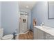 Bathroom with a glass shower, white subway tile, toilet, wood floor, and vanity sink at 430 Edgegreen Dr, Charlotte, NC 28217