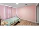Bedroom painted in pink offering a cozy and calming space with hardwood floors and natural light at 430 Edgegreen Dr, Charlotte, NC 28217