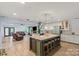 Modern kitchen featuring an island with seating, stainless steel appliances, and wood floors open to the living room at 430 Edgegreen Dr, Charlotte, NC 28217