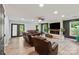 Spacious living room with a stone fireplace, hardwood floors, ceiling fan, and plentiful natural light at 430 Edgegreen Dr, Charlotte, NC 28217
