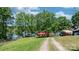 View of a charming home with a red roof, nestled by a lake and surrounded by lush greenery at 4599 B & C Dr, Catawba, NC 28609