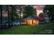 Charming lakeside home with a red roof, screened-in porch, and gazebo, nestled among mature trees under a colorful sunset sky at 4599 B & C Dr, Catawba, NC 28609