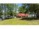 Lakefront home with a red roof, screened porch, and gazebo, surrounded by lush greenery at 4599 B & C Dr, Catawba, NC 28609